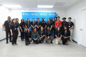 Group photo of Larkin University’s 2025 Summer Research Program (LUSRP) student cohort standing in front of a branded blue backdrop.